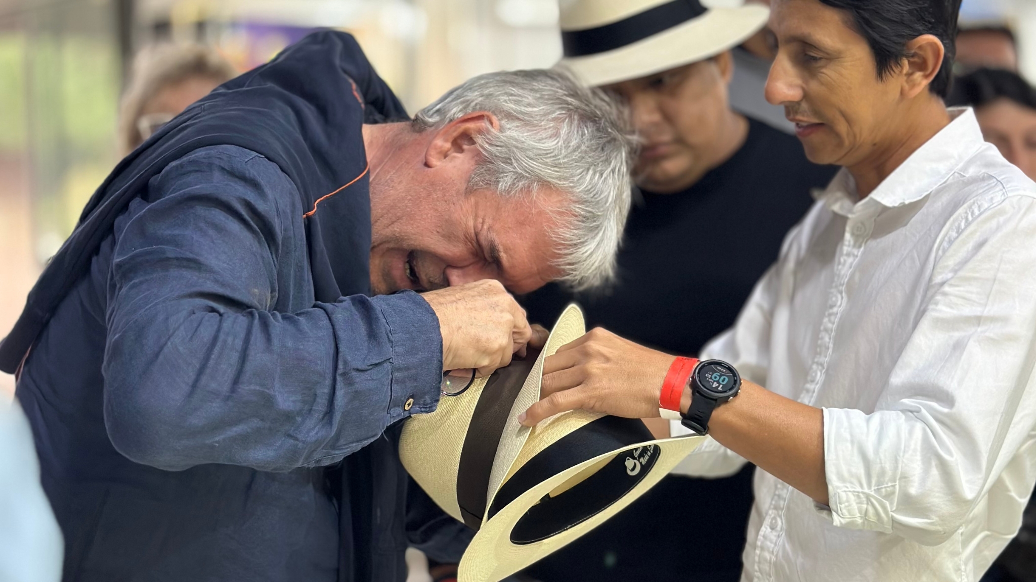 Visitante a la feria observa a través de una lupa de cuantos grados es el sombrero.